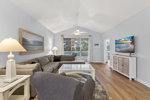 Spacious living area with vaulted ceilings, natural light, and comfortable seating for relaxing or gathering.