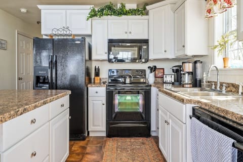Enjoy cooking in this stylish kitchen with sleek black appliances, crisp white cabinetry, and charming details that make it feel like home!  "Lake House"