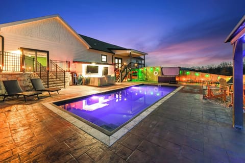 Modern outdoor pool area with colorful lighting and lounge seating at dusk