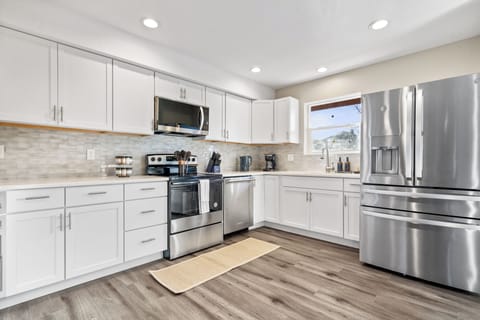 Sleek kitchen with stainless steel appliances, white cabinets, and great light.