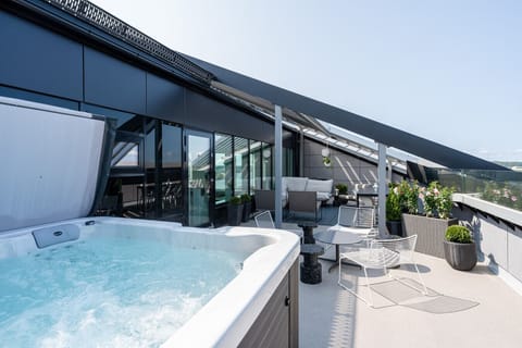 Unwind in the private jacuzzi located on the terrace, offering a luxury spa experience with a view.