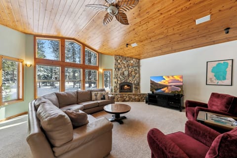 Cozy up in this stunning living room where warm wood ceilings meet stone fireplace comfort, perfect for snowy evening relaxation.