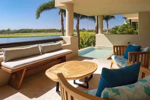 A terrace with a living area, pool, and views.