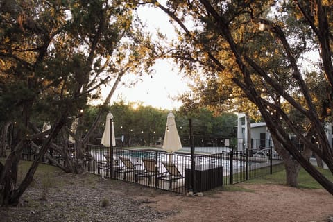 Our pool and pool deck offer guests relaxation under a canopy of trees