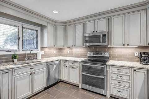 - Gourmet kitchen with granite counters, stainless appliances, and stylish backsplash
- Gray cabinetry and under cabinet lighting create a sleek, upscale atmosphere
- Fully equipped for meal prep, morning coffee, or extended vacation cooking