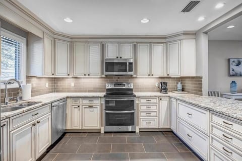 - Stylish kitchen with granite countertops, soft close drawers, and tile backsplash
- Stainless steel oven and microwave make cooking at home easy and efficient
- Recessed lighting and plenty of storage offer functionality and sleek design