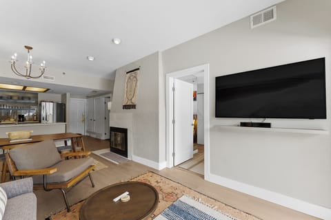 Living area featuring a flat-screen TV, queen sleeper sofa, and access to the private balcony.