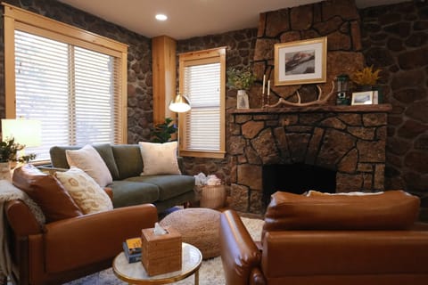 Living room with comfortable seating, bright windows, and original fireplace. *Fireplace is decorative only.