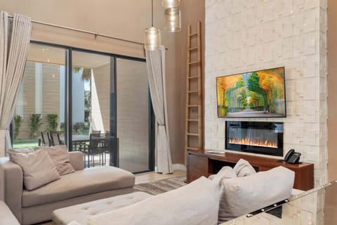 Modern oasis with fireplace, patio access, and elegant open living space
