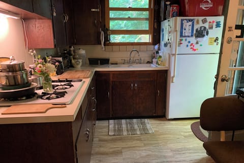 Kitchen with cooking equipment. Coffee on the freezer.