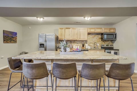 The fully equipped kitchen features stainless steel appliances, a spacious island with bar seating, and a stylish stone backsplash. Perfect for preparing delicious meals while staying connected with family and friends.





