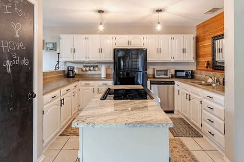 This spacious open-concept kitchen has everything you need to cook a meal from scratch—a full-size fridge, stovetop, oven, ample counter space, and room to move. It's perfect for everything from simple breakfasts to full family dinners.