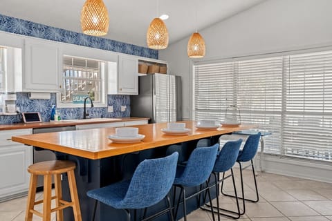 A dining table for four with a view of the kitchen creates a cozy and inviting atmosphere. It’s perfect for casual meals, allowing guests to enjoy the conversation and the action happening in the kitchen, making the space feel open and connected. Whether 