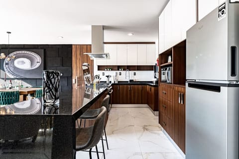 Dining space set next to a striking stone wall with abstract art