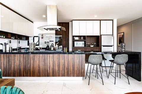 Fully equipped kitchen with sleek finishes and breakfast bar seating for four