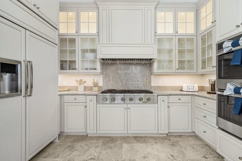 Featuring double ovens, dual dishwashers, a drawer microwave, a large refrigerator, a gas stove, and ample counter space, all fully stocked with cooking essentials