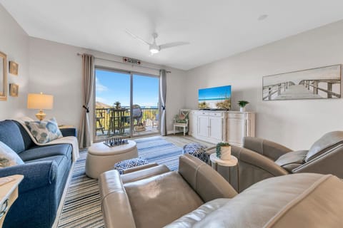 Welcome to Beach Resort 401 - Blue View! Unwind in your bright living room featuring comfortable seating, coastal artwork, and sliding doors to your private balcony with scenic views.