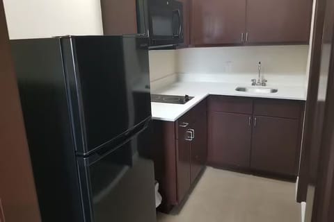 Prepare quick snacks with fridge, microwave, sink, and cooktop.