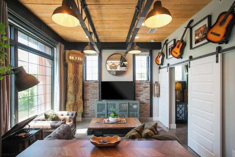 Industrial living room with exposed beams and guitar wall art
