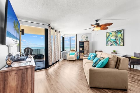 This cheerful space features vibrant coastal décor, a queen-size sleeper sofa with beachy pillows, and a charming reading nook by the window.