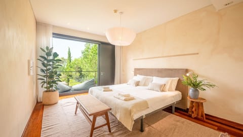 The spacious master bedroom opens to a private balcony with calming views of lush greenery. #SuiteEscape #NatureViews #Comfort #Luxury #portugal #pt #troia