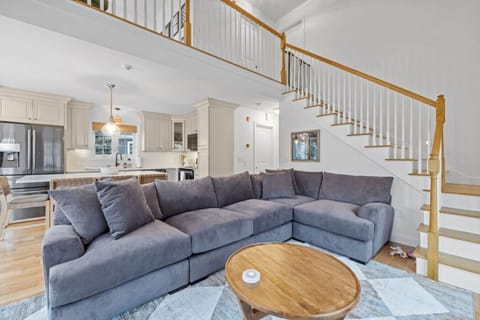 Inviting living area featuring natural light, comfortable seating, and open flow to upstairs