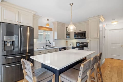 Modern kitchen featuring center island, high-end appliances, and elegant lighting fixtures