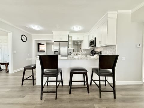 Fully equipped kitchen featuring a spacious kitchen island with 4 bar stools.
