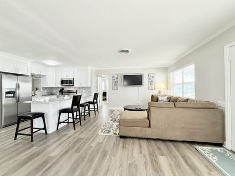 Fully equipped kitchen featuring a spacious kitchen island with 4 bar stools.