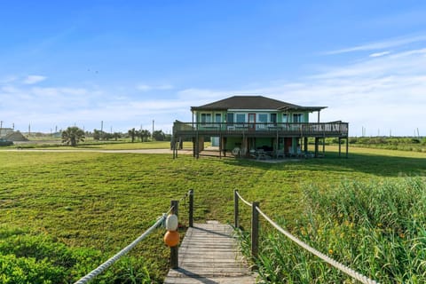The look of the house coming from the ocean over the bridge.