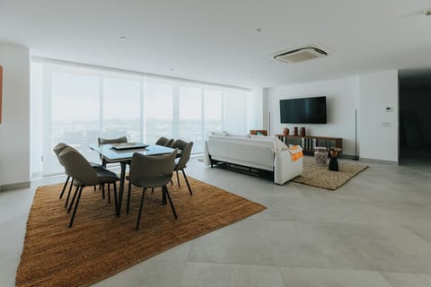 Unwind in your spacious living and dining area, where floor-to-ceiling windows frame stunning sea views. Enjoy meals together, relax on the plush sofa, and feel the calming ocean breeze as you make yourself at home.