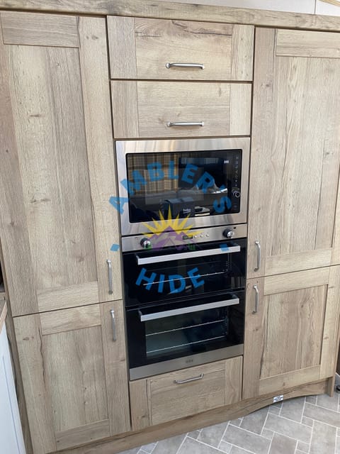 Gas, Grill Oven & Microwave.Storage Cupboard on left & Fridge/Freezer on right.