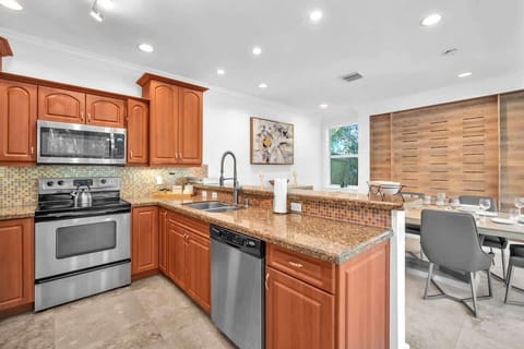 A spacious kitchen with modern appliances and plenty of counter space, perfect for preparing meals with ease. The open layout flows into the dining area, making it great for entertaining or casual dining.