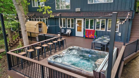 Large deck overlooking the Rock River with a hot tub, dining table, suana, and plenty of seating options.