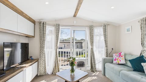 Open-plan living area with breakfast bar, TV and fire.