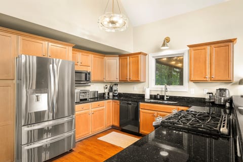 A chef-ready kitchen — with elegant lighting, spacious granite counters, and virtually every tool for group feasts or casual bites