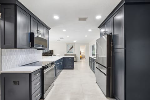 Fully-stocked kitchen with oven, microwave, fridge, dishwasher