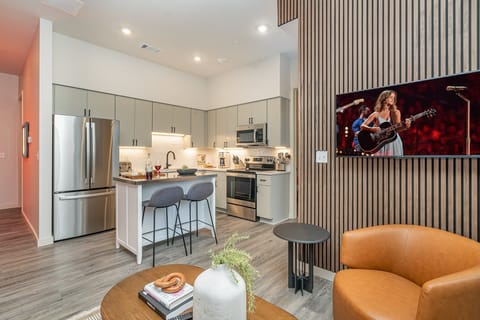 Unit 1: Fully equipped kitchen featuring  stainless steel appliances with a kitchen island offering bar seating for 2 guests.