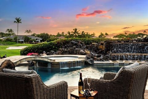 Sip wine on the lanai at sunset, surrounded by lava rock landscaping and tranquil twilight skies.
