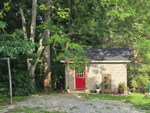The cottage entrance, porch, and gravel parking area