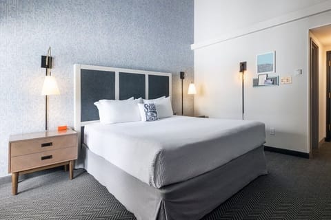 Unwind in a crisp king bed under warm bedside lighting.