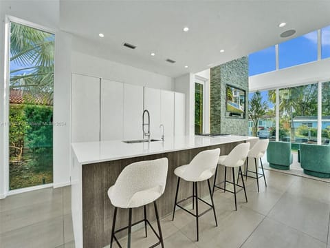 Refined culinary space showcasing contemporary design excellence with luxury breakfast bar and seamless outdoor connections