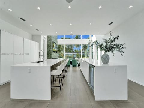 Refined culinary space showcasing contemporary design excellence with luxury double island configuration and abundant natural light