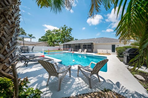Enjoy a spacious backyard with a large pool and volleyball net with lounging.