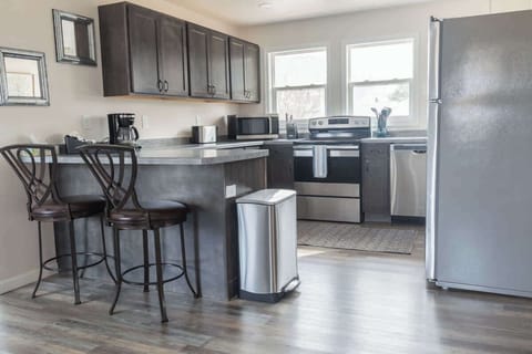 This sleek, open-concept kitchen features stainless steel appliances and a convenient breakfast bar, perfect for casual dining or entertaining. The open layout makes it easy to interact with family and friends while cooking.