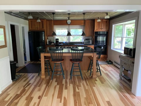 Kitchen with hickory flooring, and island with marble top. View from great room