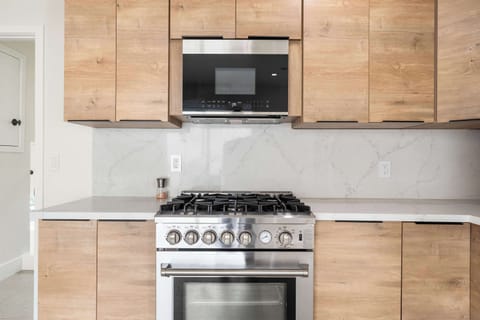 Perfect for culinary enthusiasts! Cook with ease on our stainless steel gas range, complemented by sleek cabinetry and a built-in microwave. The stylish backsplash and ample counter space make meal prep a joy.