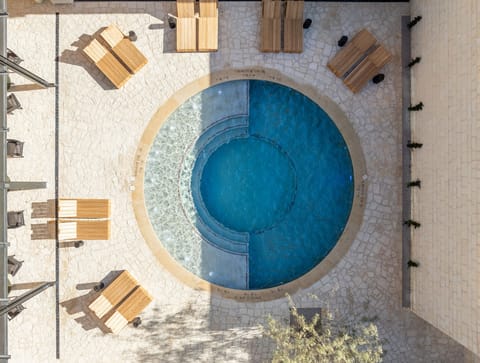 Dive into a sunlit pool oasis with serene seating.
