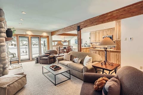 Spacious Great Room/Family Room featuring a cozy gas fireplace and plenty of seating for everyone. Step out onto the expansive deck, where you'll be treated to breathtaking views of the mountain SKY Chutes, ski slopes, and the lush golf course