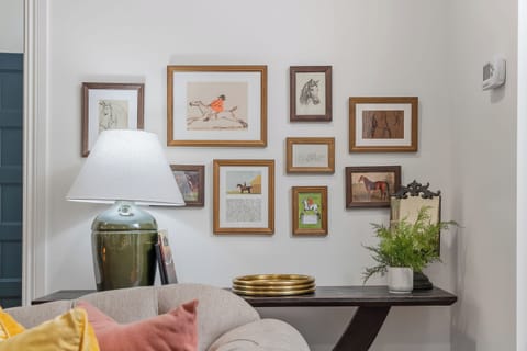 A thoughtfully styled living room showcasing an equestrian-inspired art collage.